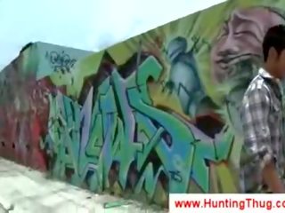 Baltie bloke mēģina līdz pick augšup melnas graffiti mākslinieks